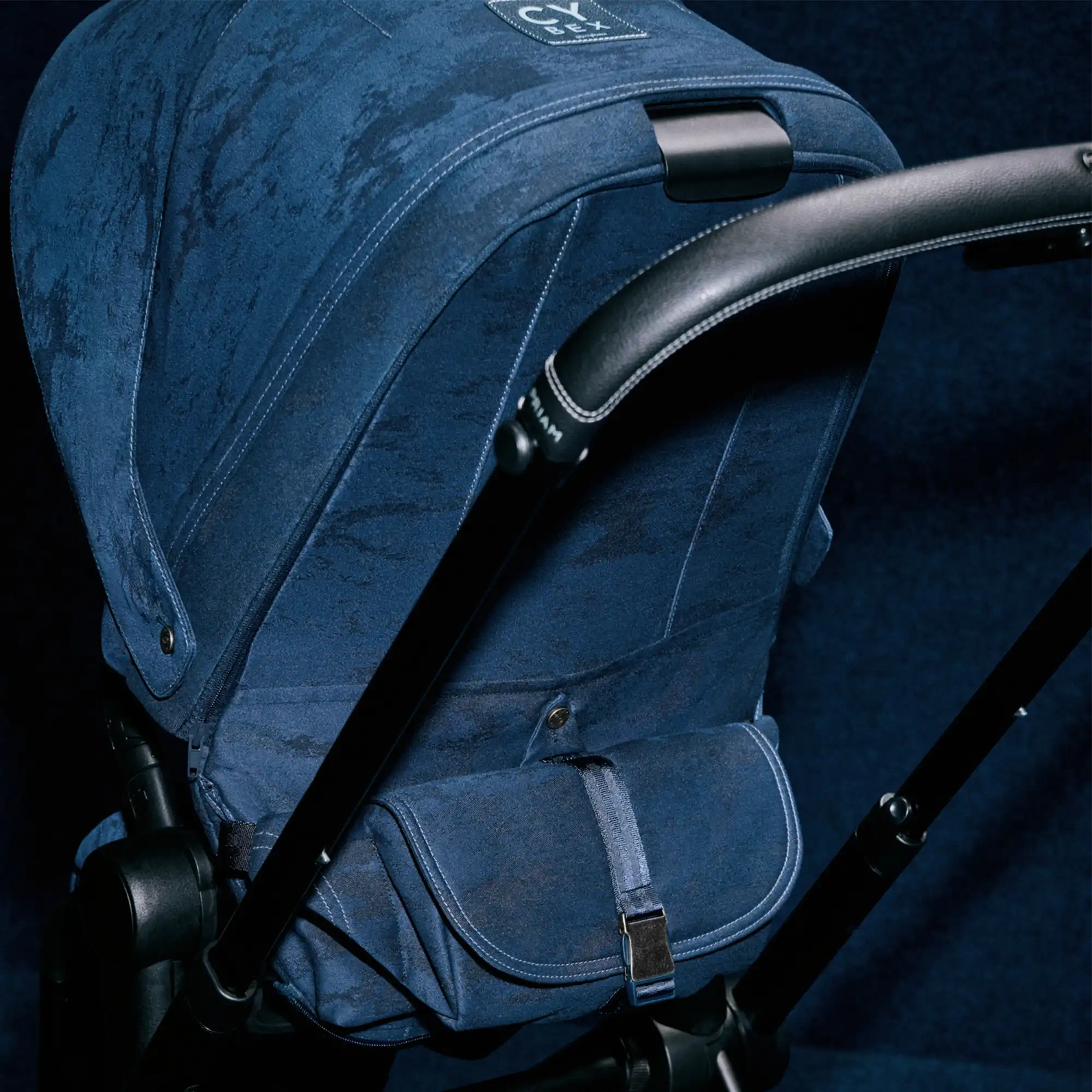 Detal tapicerki wózka Cybex Priam 4.0 Rebellious Luxury – szwy, kieszeń i struktura denimu