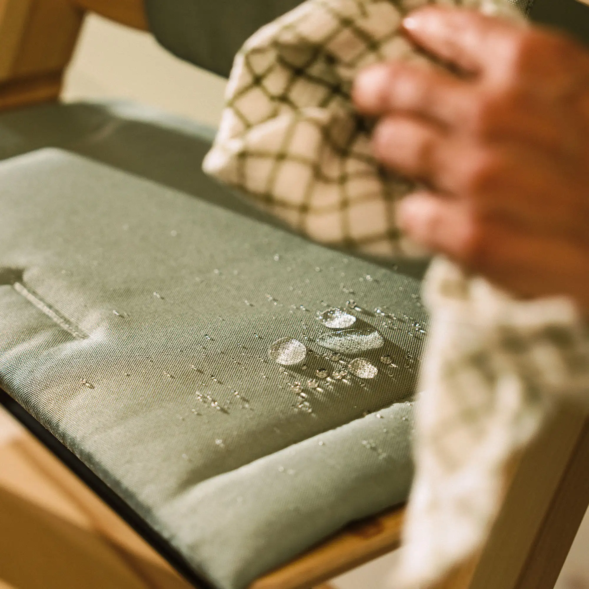 Zbliżenie na fakturę materiału i antypoślizgowy spód poduszki Stokke Tripp Trapp Cushion V2 w kolorze Beige